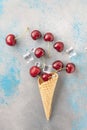 Fresh cherry fruits and ice cubes coming out from ice cream cone