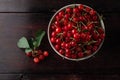 Fresh cherry on plate with summer flowers on rustic wooden background. fresh ripe berries. sweet cherries. top view Royalty Free Stock Photo