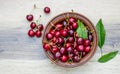 Fresh cherry on plate on wooden grey background. fresh ripe cherries. sweet cherries. Sweet cherries bowl with leaves. Royalty Free Stock Photo