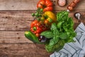 Fresh cherry tomato branches, basil leaves, napkin, pepper and pepper mill on old wooden rustic background. Food cooking backgroun Royalty Free Stock Photo