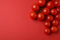 Fresh cherry tomato branches on red background