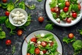 Fresh Cherry Tomato, Mozzarella salad with green lettuce mix and red onion. served on plate. healthy food. Royalty Free Stock Photo