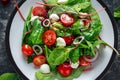 Fresh Cherry Tomato, Mozzarella salad with green lettuce mix and red onion. served on plate. healthy food. Royalty Free Stock Photo