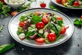 Fresh Cherry Tomato, Mozzarella salad with green lettuce mix and red onion. served on plate. healthy food. Royalty Free Stock Photo