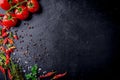 Fresh cherry tomatoes on a black background with spices with slate plate. Top view with copy space. Royalty Free Stock Photo