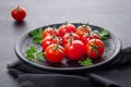 Fresh cherry tomatoes on black round plate,  on dark background Royalty Free Stock Photo