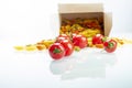 Tomatoes between colored pasta on white reflexive glass Royalty Free Stock Photo