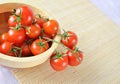 Fresh cherry tomatoes on the vine in a wooden plate Royalty Free Stock Photo