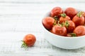 Fresh cherry tomatoes in white ceramic bowl on rustic wooden background. Ingredients for tomato sauce. Vegetarian food. Soft Royalty Free Stock Photo