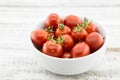 Fresh cherry tomatoes in white ceramic bowl on rustic wooden background. Soft focus. Royalty Free Stock Photo