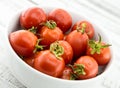 Fresh cherry tomatoes in white ceramic bowl on rustic wooden background. Soft focus. Royalty Free Stock Photo