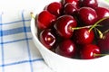 Fresh cherry in white ceramic bowl on wooden white background Royalty Free Stock Photo