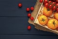 Fresh cherry and yellow tomatoes in wooden box on burlap and dark wooden table. Vegetables in the box with wood shavings for Royalty Free Stock Photo