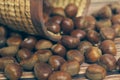 Fresh chestnuts in the basket falling on a brown wooden table Royalty Free Stock Photo