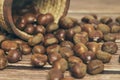 Fresh chestnuts in the basket falling on a brown wooden table Royalty Free Stock Photo