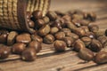 Fresh chestnuts in the basket falling on a brown wooden table Royalty Free Stock Photo