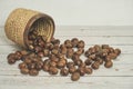 Fresh chestnuts in the basket falling on a white wooden table Royalty Free Stock Photo