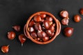 Fresh chestnuts in a clay bowl on black background Royalty Free Stock Photo