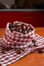 Fresh chestnuts in a red checkered cloth bag on a wooden kitchen table Royalty Free Stock Photo