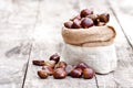 Fresh chestnuts in sack bag on the old wooden table