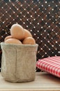 Fresh chicken eggs in bag on wooden table and bamboo weave background