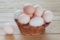 Fresh chicken eggs in wicker basket on wooden table Royalty Free Stock Photo