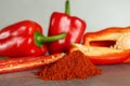 Fresh chili and bell peppers with paprika powder on grey table, closeup Royalty Free Stock Photo