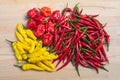 Mixed red and yellow hot chili peppers on a light wooden table