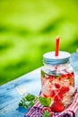 Chilled berry infused strawberry punch bowl in a glass jar