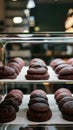 Fresh chocolate cookies in glass showcase at cafe, selective focus