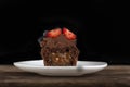 Fresh chocolate muffin with berries. Half chocolate cupcake with filling in cut on wooden surface on black background Royalty Free Stock Photo