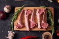 Fresh chopped calf on a cutting board with rosemary branches, yellow and red tomatoes, garlic, colorful peas. Meat ingredients.