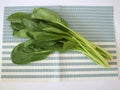 Fresh choy greens on a striped cloth background