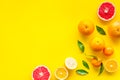 Fresh citrus frame. Oranges, tangerines, grapefruits, leaves on yellow background top-down copy space