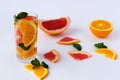 Fresh citrus fruit on white background. refreshing cocktail with slices of fresh orange and grapefruit with green mint leaves on w