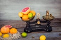 Fresh citrus fruits in vintage scale and several oranges, lemons, grapefruit, lime on the old rustic wooden table with a few Royalty Free Stock Photo