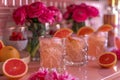 Fresh Citrus Refreshments with Garnished Grapefruit Slices and Vibrant Pink Roses on Elegant Setting