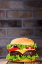 Fresh classic hamburger on rustic wooden table and brick wall on background