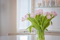 Pink flowers white kitchen. Valentine\'s day home. Clean home office, tulips for Women`s Day celebration. Scandinavian Nordic