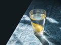 Fresh clean water in a glass with slices of lemon. Lemonade on a beautiful blue tablecloth in the bright morning sun. Living water Royalty Free Stock Photo