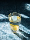 Fresh clean water in a glass with slices of lemon. Lemonade on a beautiful blue tablecloth in the bright morning sun. Living water Royalty Free Stock Photo