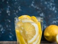 Fresh clean water in a glass with slices of lemon. Lemonade on wooden table and blue background. Living water, healthy drink Royalty Free Stock Photo