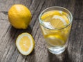 Fresh clean water in a glass with slices of lemon. Lemonade on wooden table. Living water, healthy drink