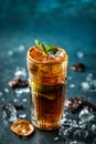 Fresh cocktail with cola, lime, chocolate and ice in glass on dark blue background. Summer cold drink and cocktail