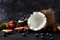 Fresh coconut , close up, with blue berry, with strawberry, on a black background. - Image