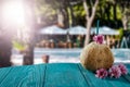 Fresh coconut drink and blurred exotic trees and outdoor restaurant background. Copy space for advertising product.