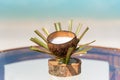 Fresh coconut juice in designed cup on the glass table at the beach with ocean