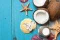 Fresh coconuts, coconut oil in a jar, shells and starfish on natural turquoise wooden background Royalty Free Stock Photo