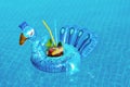 Fresh coctail mojito on inflatable blue peacock toy at swimming pool. Vacation concept
