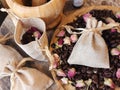 Coffee beans and dried rose buds aromatherapy sachets and mortar.